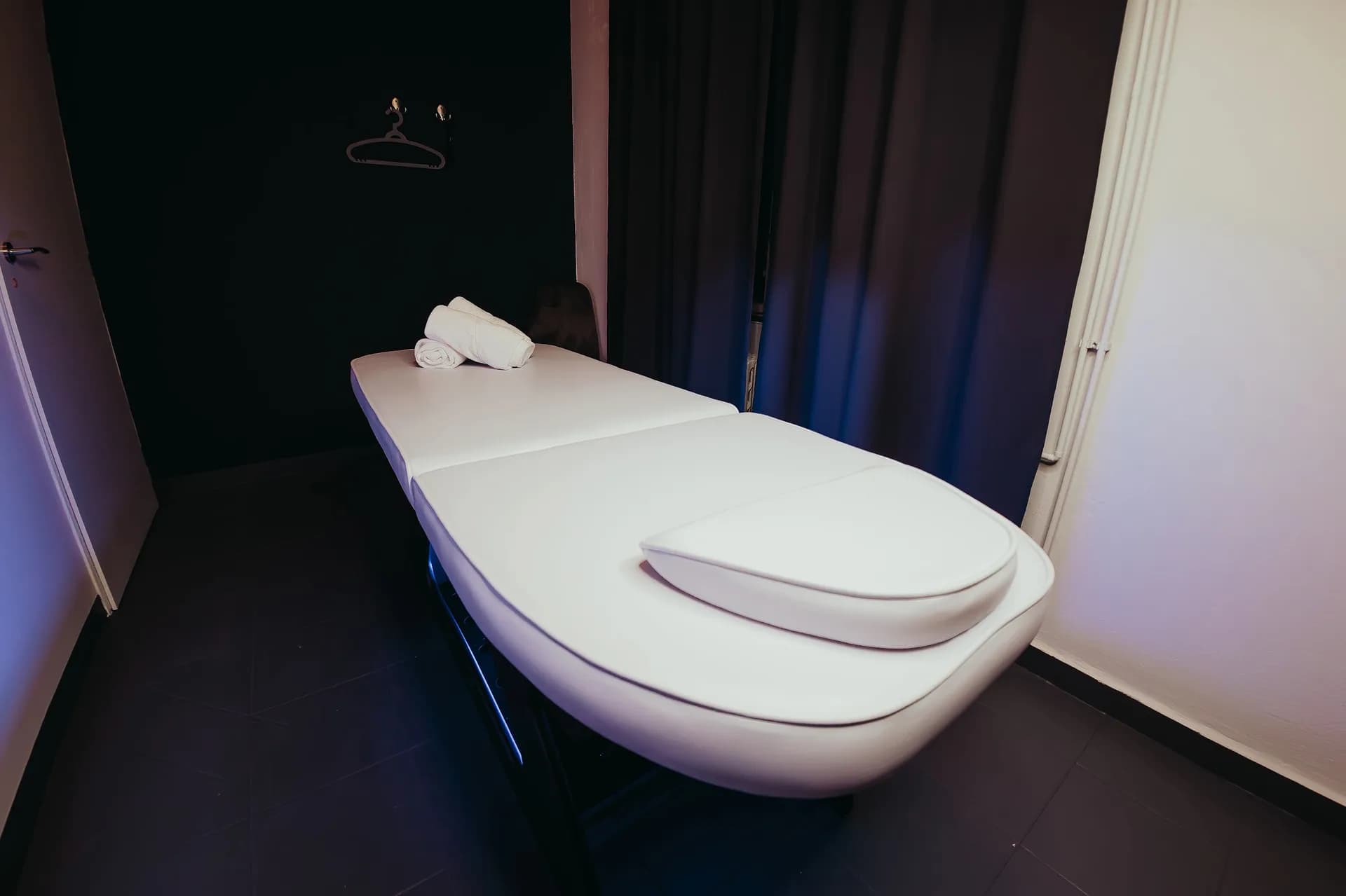 Enlarge photo: The lit street-level entrance to the Massage DeLuxe salon at Na Bělidle 63/1 in Prague 5, Smíchov
