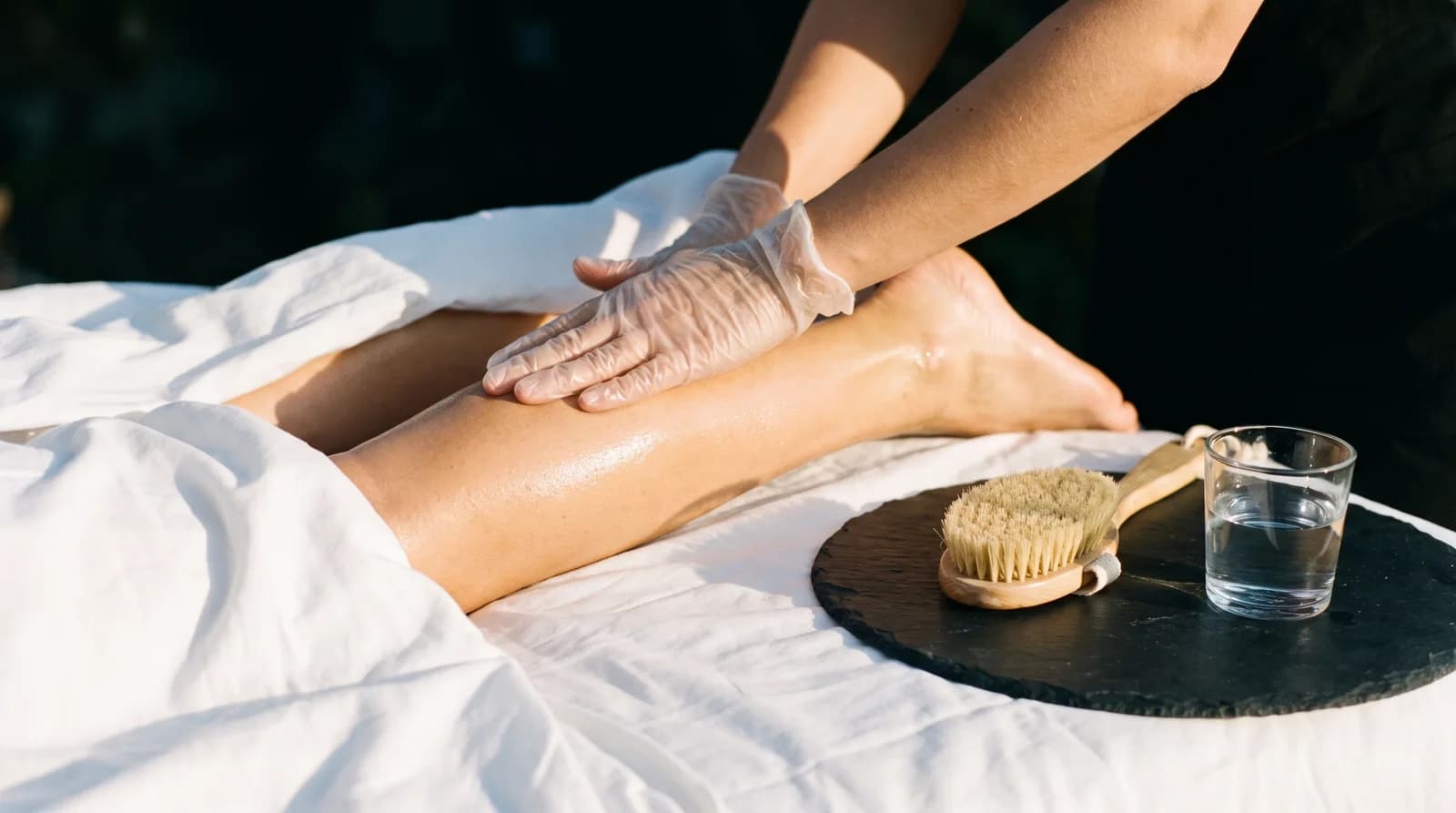 Detail rukou terapeutky při jemné lymfodrenážní masáži nohou v salonu Massage DeLuxe